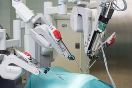 Auf dem Bild sieht man die DaVinci Operationstechnik. Eine roboterartige Maschine. Abgebildet sind 3 Arme mit jeweils einem Kneifer.