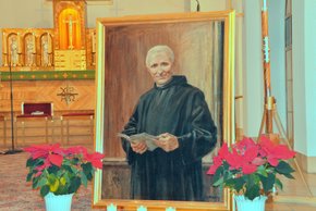 Auf dem Bild sieht man ein Gemälde von Frater Eustachius Kugler. Daneben stehen zwei rote Blumenpflanzen.