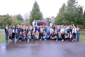 Man sieht 104 Schüler und Schülerinnen auf einem Hof, im Hintergrund Bäume.