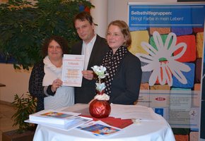 Antje Liesener (r.) vom Paritätischen Gesamtverband überreicht das Gütesiegel an Selbsthilfekoordinator Dr. Heribert Stauder des Krankenhauses Barmherzige Brüder und KISS-Koordinatorin Lisbeth Wagner.