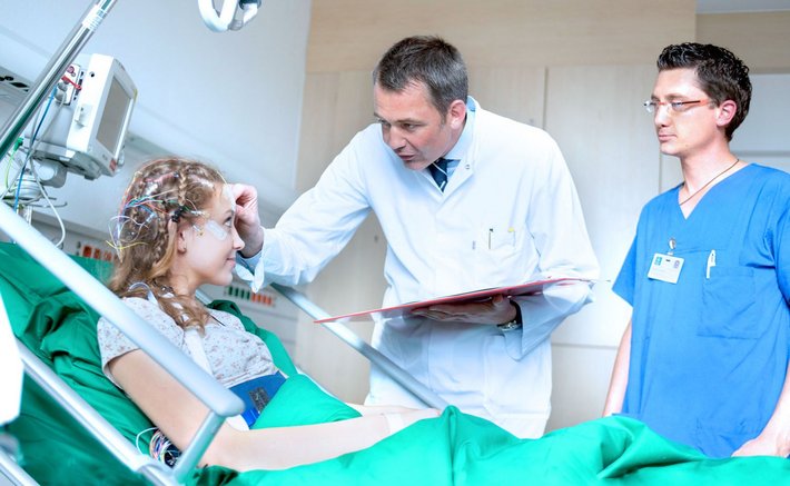 Chefarzt Prof. Dr. Hendrik Pels legt bei einer Patientin die Elektroden für eine EEG-Untersuchung an.