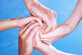 Auf dem Bild sieht man Hände, die ineinander verschlossen sind und somit einen Kreis bilden.