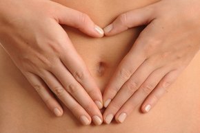 Auf dem Bild sieht man einen Bauch. Um den Nabel herum ist ein aus Händen geformtes Herz.