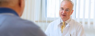 Chefarzt Prof. Pompiliu Piso im Gespräch mit einem Patienten.