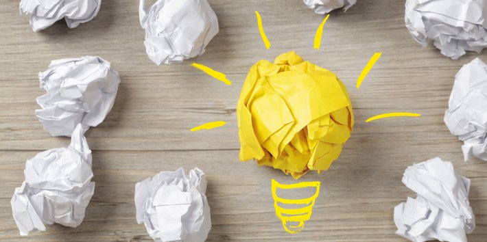 Eine Birne und Papierbälle stehen für "Idee, Konzept"