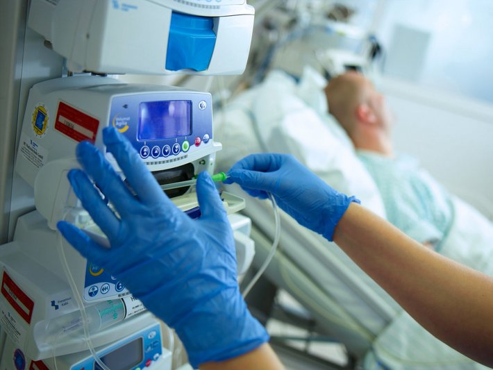 Zwei Pflegekräfte kümmern sich auf der Intensivstation um einen Patienten.