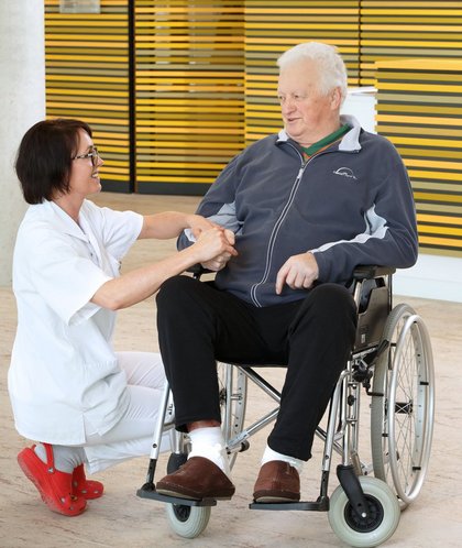 Patient im Rollstuhl mit Krankenpflegerin